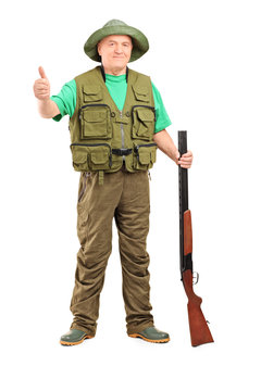 Full Length Portrait Of A Hunter Holding A Rifle And Giving A Th