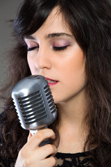 Attractive young  woman with a retro microphone