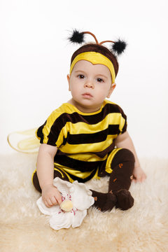 Baby earing bee costume sitting on the floor