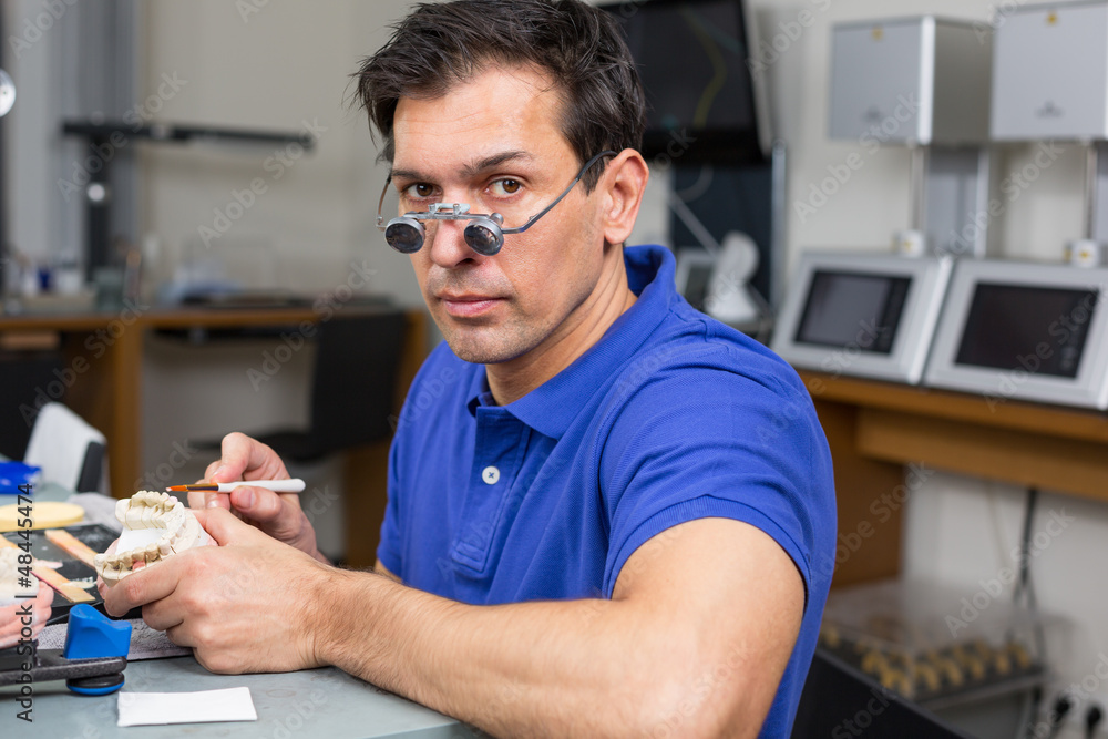 Sticker Dental lab technician appying porcelain to mold