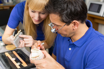 Two dental technicians choosing the right colour for dental porc