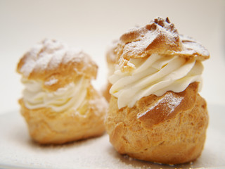 Choux pastry buns, filled with whipped cream, on a plate