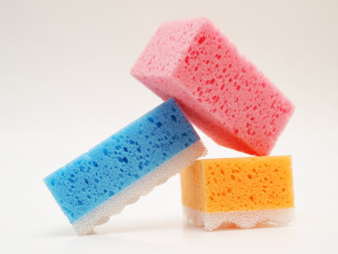 Pink, blue and orange sponge, isolated towards white background - Powered by Adobe