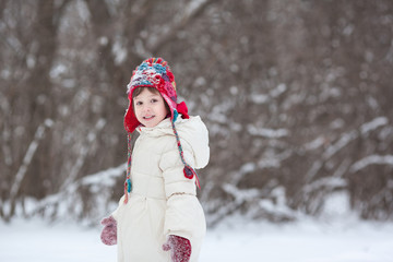 Adorable preschooler girl in beautiful winter park