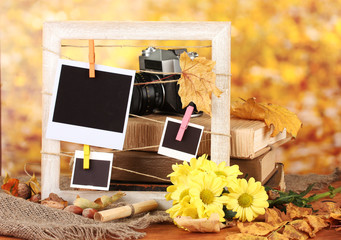 Autumnal composition with flowers, photo cards, wooden frame