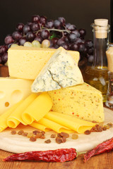 Various types of cheese on wooden board