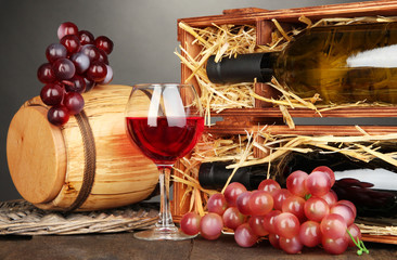 Fototapeta na wymiar Drewniany przypadku butelek wina, beczkę, lampki i winogron