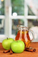 Full jug of apple juice and apple