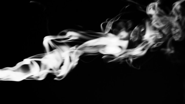 Real white smoke over black background.
