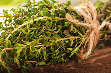 Thyme bunch with a rough rope on a wooden board