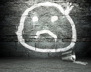 Graffiti wall with sad face, street background
