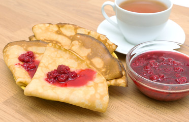 Pancakes with raspberry jam and a cup of tea