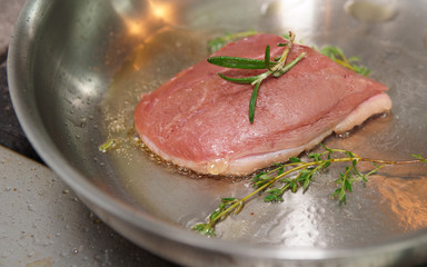Duck berast being fried in pan