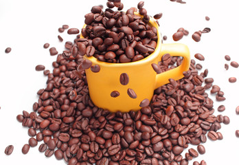 coffee beans pouring in a yellow cup