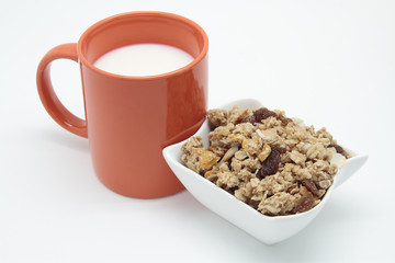 orange mug of breakfast with milk and cereals