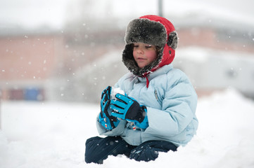 Portrait of young kid playing in the snow.