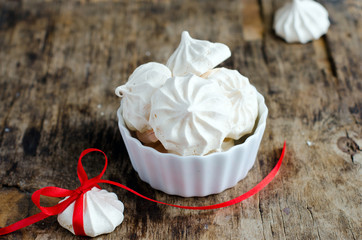 Meringue in white plate on a wooden table