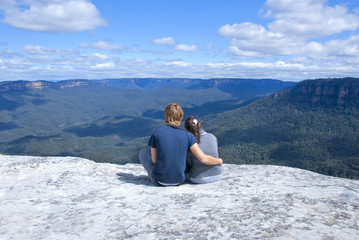 Couple sitting on top of mountain