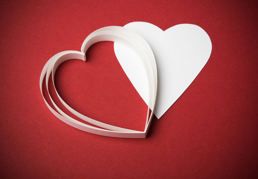 Two white paper hearts on the red with copy space