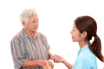 手を取り合い微笑む高齢者と介護士