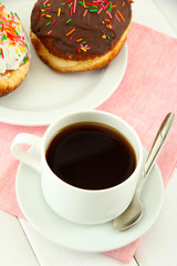 Tasty donuts on color plate on light wooden background