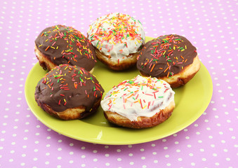 Tasty donuts on color plate on color background