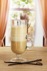 Fragrant coffee latte in glass cup with vanilla pods,