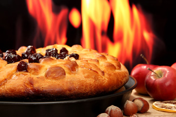 tasty homemade pie with jam, on wooden table on flame