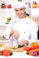 Young woman chef cooking in kitchen