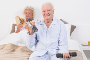 Elderly man lifting hand weights