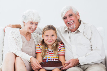 Little girl celebrating birthday with grandparents