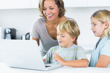 Fototapeta na wymiar Matka za pomocą laptopa z dziećmi