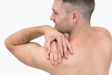 Rear view of shirtless man with shoulder pain