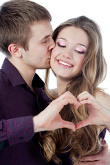 Young couple forming heart shape with their hands isolated on wh