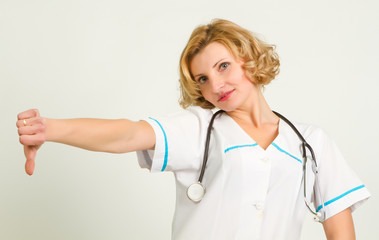 Displeased medical doctor woman showing thumbs down gesture