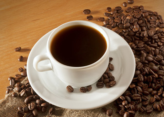 A cup of coffee on a wooden table top view