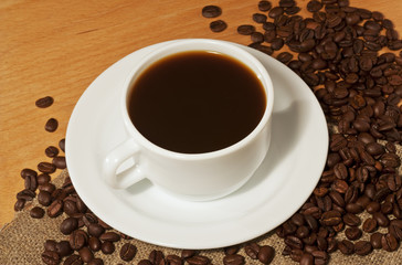 A cup of coffee with a lot of coffee beans
