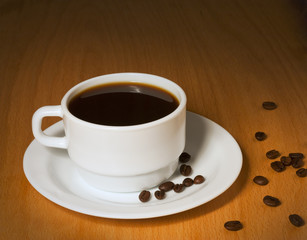 White cup with hot coffee on a saucer