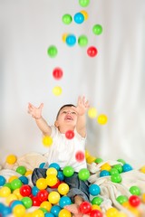 Fototapeta na wymiar Cute boy playing colorful balls