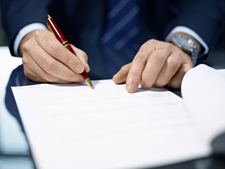 Close up of businessman signing a contract.