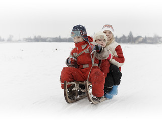 three children together on sledge, white bacground