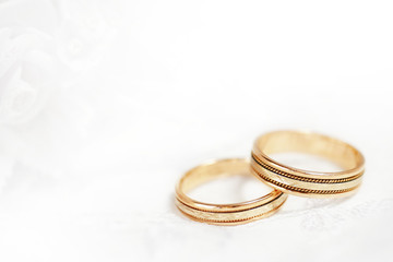 Two golden wedding rings with seamless flower decorations