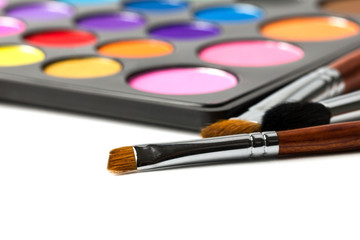 Close-up of make-up brushes with colorful eyeshadow palette. 
