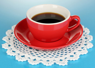 A red cup of strong coffee on blue background