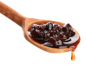 tasty berry jam in wooden spoon, isolated on white