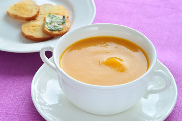 Close-up of roasted-pumpkin soup in a white bowl.