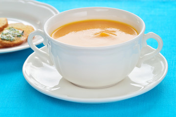 Close-up of roasted-pumpkin soup in a white bowl.