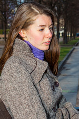 Beautiful and young woman resting in a park in autumn