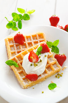 Crisp golden waffles, strawberries and cream