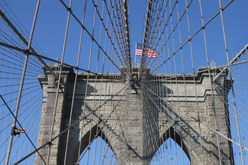 Fototapeta premium Amerykańska flaga na szczycie słynnego Brooklyn Bridge